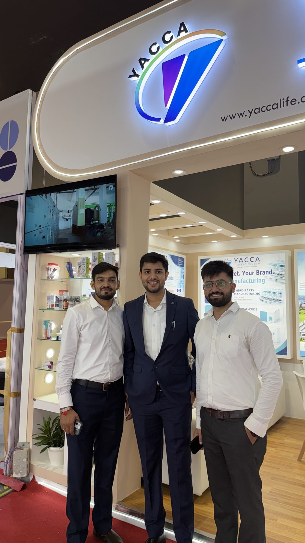 Yacca Lifesciences team members beside the product display shelves